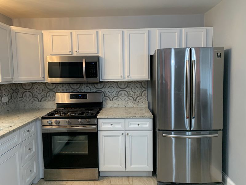 White painted kitchen cabinets with stainless appliances